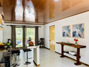 a kitchen with a counter and a table in it at Casa Antema Tamarindo, maison luxe, piscine, jungle, yoga, gym in Tamarindo
