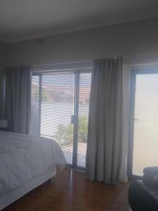 a bedroom with a bed and a large window at 16 on Point in Parow