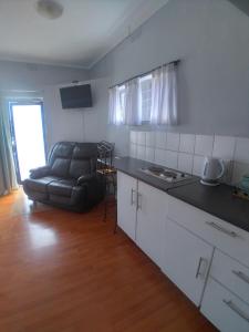 eine Küche und ein Wohnzimmer mit einem Sofa in der Unterkunft 16 on Point in Parow