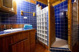 bagno piastrellato blu con lavandino e doccia di Mango Inn Resort a Útila