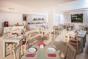 a dining room with tables and chairs in a restaurant at Astra Village & Suites in Hersonissos