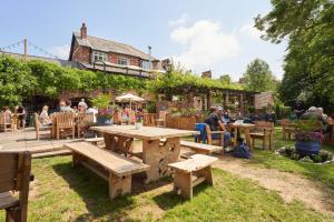 a group of people sitting at tables in a garden at Mill on the Exe in Exeter