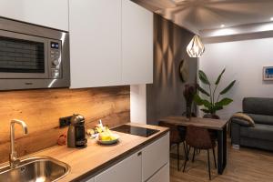 a kitchen with a counter top with a sink and a microwave at Mina50 by 7Escalones in Rota