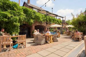 un gruppo di persone seduti a un tavolo fuori da un ristorante di Mill on the Exe a Exeter