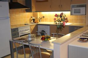 a kitchen with a table with a vase of flowers at Apartament La Font in Palafrugell