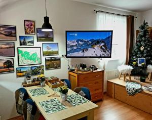 スヴォボダ・ナト・ウーポウにあるApartmán u Zuzankyのテーブルと壁にテレビが掛かっている部屋