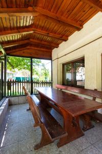 une table en bois et des bancs sur une terrasse dans l'établissement Silva Cabin - In the heart of Bran, next to the Castle w/ free parking, à Bran
