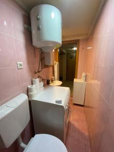 uma casa de banho com WC e uma luz na parede em Apartman Benjamin em Tuzla