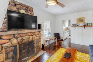 sala de estar con chimenea de piedra y TV de pantalla plana en Rocky Mountain Resting Place, en Estes Park