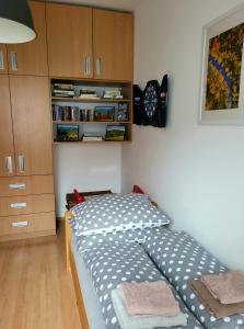 1 dormitorio con 1 cama y reloj en la pared en Apartmán u Zuzanky, en Svoboda nad Úpou