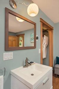 y baño con lavabo blanco y espejo. en Bell In The Woods B&B, en Seward