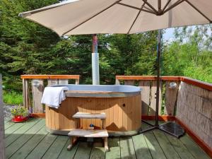 an umbrella and a hot tub on a deck at Norwegian Wood in Rhayader