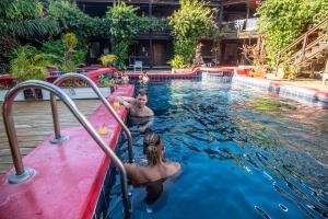 un hombre y una mujer en una piscina en Mango Inn Resort, en Utila