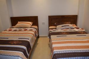 dwa łóżka siedzące obok siebie w pokoju w obiekcie Sharm Hills Resort - Luxury Apartment w Szarm el-Szejk