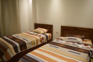 two beds sitting next to each other in a bedroom at Sharm Hills Resort - Luxury Apartment in Sharm El Sheikh
