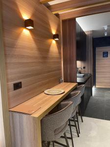 a kitchen with a wooden counter with stools at Woodside Kopaonik & SPA by Slopeview in Kopaonik