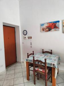 una sala da pranzo con un tavolo e un orologio a parete di Casa Margherita piano primo a Mondragone