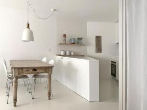 een witte keuken met een houten tafel en stoelen bij Chesa Auricula in Pontresina