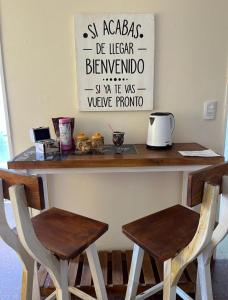 a counter with two chairs and a table with a counter top at Departamento en Ramallo in Ramallo