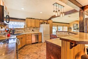a kitchen with wooden cabinets and a white refrigerator at South Dakota Vacation Rental Near Mount Rushmore in Hermosa