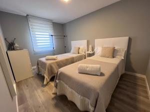 two beds in a room with a window at Apartamento da Fraga in Arzúa