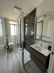 a bathroom with a sink and a shower and a toilet at Apartamento da Fraga in Arzúa
