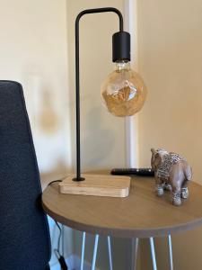 a table with a lamp and a toy elephant on it at Apartamento da Fraga in Arzúa