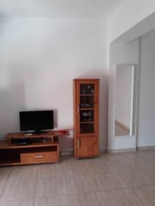 sala de estar con TV y armario de madera en Piso por la Plaza Sol con WiFi, en Alicante