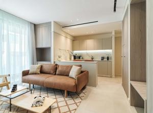 a living room with a couch and a kitchen at LIV Mackenzie Beach Suites Larnaca ADULTS ONLY in Larnaca