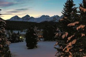 uma vista para uma casa na neve com montanhas em Chesa Linaira em Pontresina