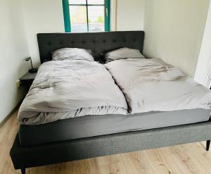ein Bett mit weißer Bettwäsche und Kissen darauf in der Unterkunft Das Chorzimmer- Ambiente am Fuße der Burg in Holzhausen