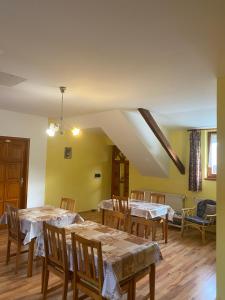 comedor con mesas y sillas y paredes amarillas en Gaál Vendégház, en Szentgotthárd