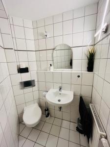 a white bathroom with a toilet and a sink at Das Chorzimmer- Ambiente am Fuße der Burg in Holzhausen +21 photos