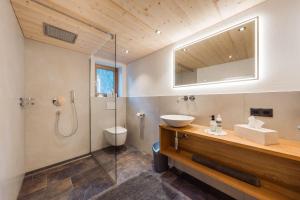 a bathroom with a shower and a sink and a toilet at Ferienhaus Bergfrieden in Partenen