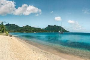 vista su una spiaggia con barca in acqua di Fare Tiare a Fare (Huahine Nui)