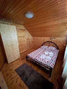 1 dormitorio con 1 cama en una habitación de madera en Vila Maria Dambovicioara, en Dîmbovicioara