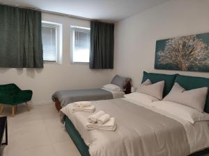a bedroom with two beds and a chair and windows at DA ANNA locazione turistica in Verona +3 photos
