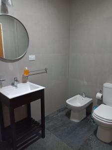 a bathroom with a toilet and a sink and a mirror at Bahia sin fondo in Puerto Madryn
