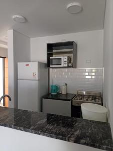 a kitchen with a white refrigerator and a microwave at Bahia sin fondo in Puerto Madryn
