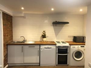 a kitchen with a sink and a washing machine at Comfortable Modern Home, Self Catering Flat, Newly refurbished, town centre, free parking in Cheltenham