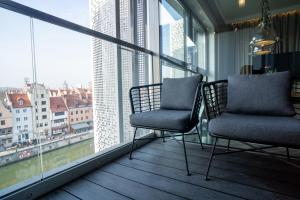 two chairs on a balcony with a view of a city at My River Side in Gdańsk