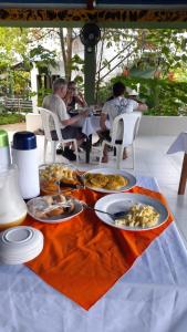 un gruppo di persone seduti a un tavolo con cibo di Wikungo Hotel a Puerto Nariño