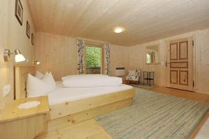 a bedroom with a bed and a table and a window at Ferienhaus Bergfrieden in Partenen