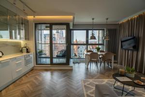 a kitchen and living room with a view of a city at My River Side in Gdańsk