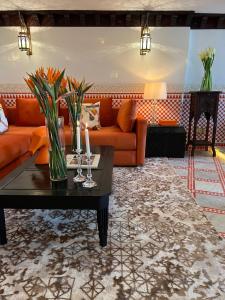 a living room with an orange couch and a table at Palais De Fès Suites & Spa in Fès