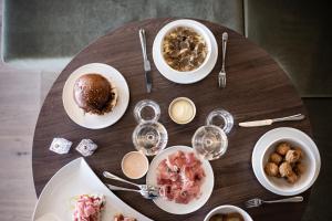 a wooden table with plates of food and wine glasses at Badia Hill in Badia