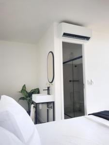 a white bedroom with a sink and a mirror at Capsula Hotel Sao Paulo - Paulista in São Paulo