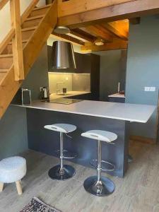 eine Küche mit zwei Barhockern und einer Theke in der Unterkunft Courchevel 1650 appartement cosy 6 personnes in Courchevel