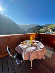 a table on the deck of a balcony with a tableablish at Courchevel 1650 appartement cosy 6 personnes in Courchevel