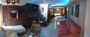 sala de estar con sofá y pared de ladrillo en "A" SPAcio HOSTEL -HABITACION PRIVADA- en Mendoza